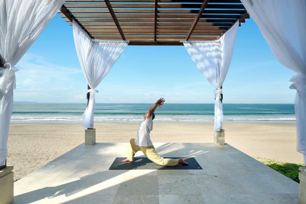The Seminyak Beach Resort & Spa Экстерьер фото A man practicing yoga at the beach